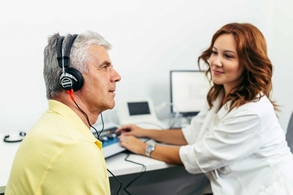 Man having his hearing tested to see if he needs hearing aids. 