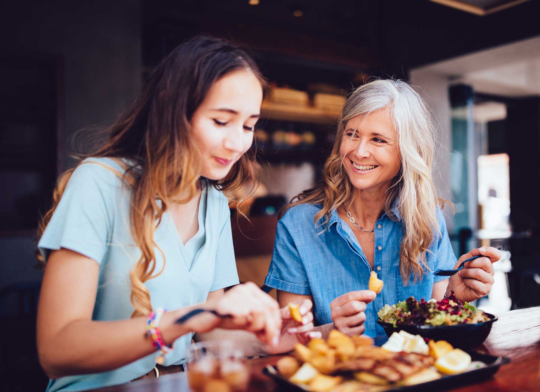 Mother with a hearing aid talking to her teenage daughter.